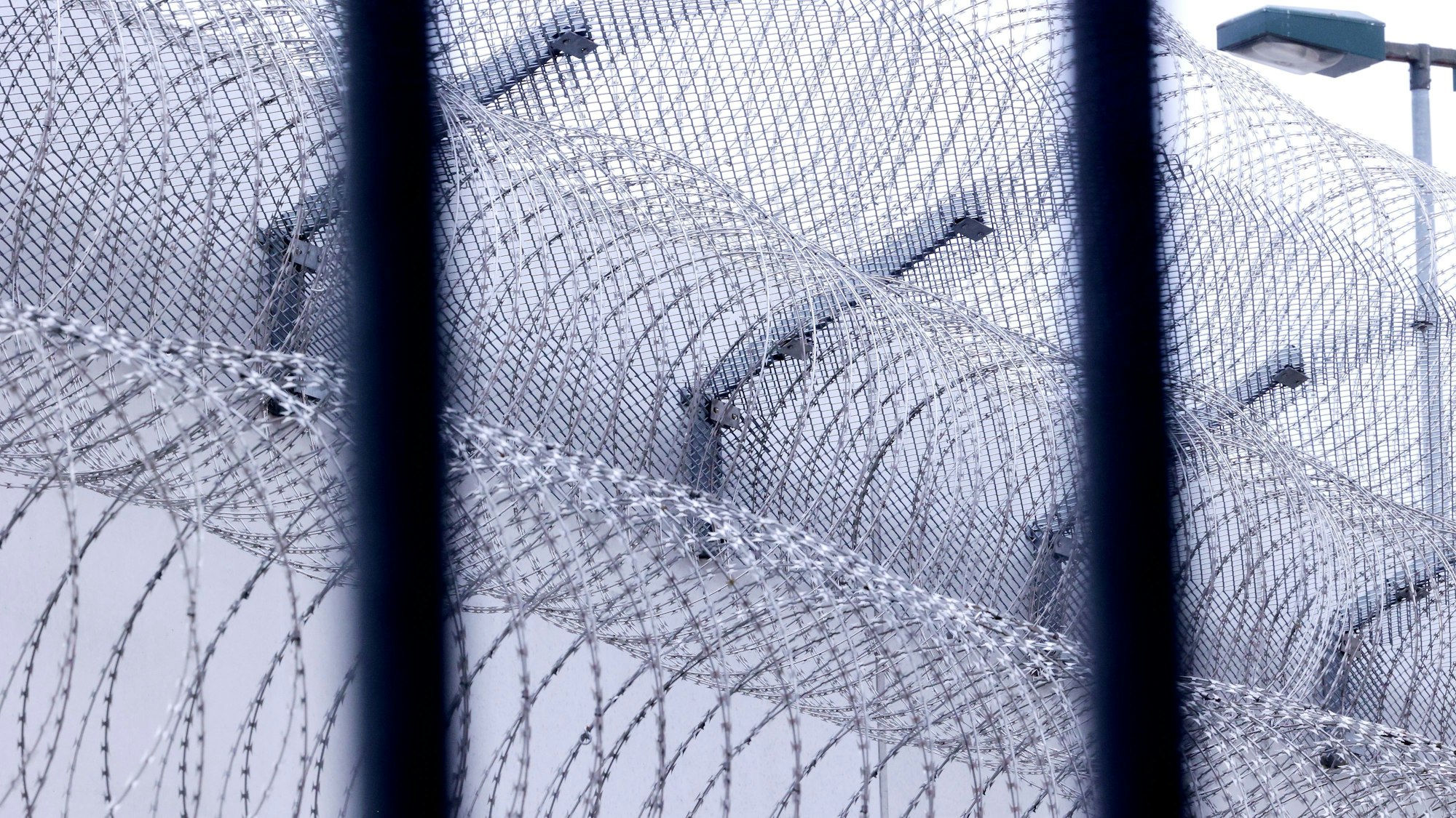 Sogenannter Nato-Draht sichert einen Bereich in der Justizvollzugsanstalt in Willich. In Frankreich ist ein Häftling bei der Entlassung eines Mitgefangenem in dessen Tasche aus dem Gefängnis geflohen.