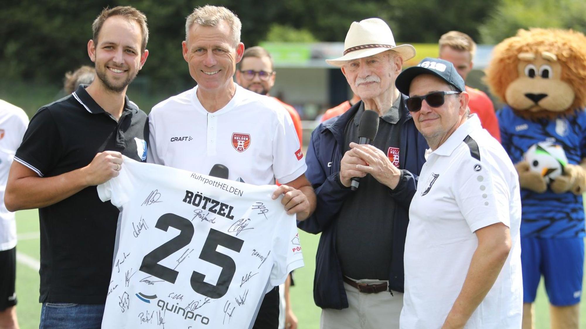 Das von den Ruhrpott-Helden unterzeichnete Trikot: Hannes Rötzel, Ingo Anderbrügge, Herner Hansch und Guido Weber freuten sich über die 5000 Euro, die bei der Versteigerung zusammenkamen.