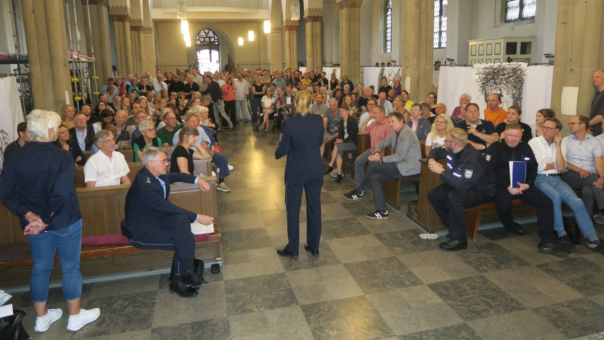 Etwa 250 bis 300 Menschen sitzen oder stehen in der Ehrenfelder Kirche St. Joseph.