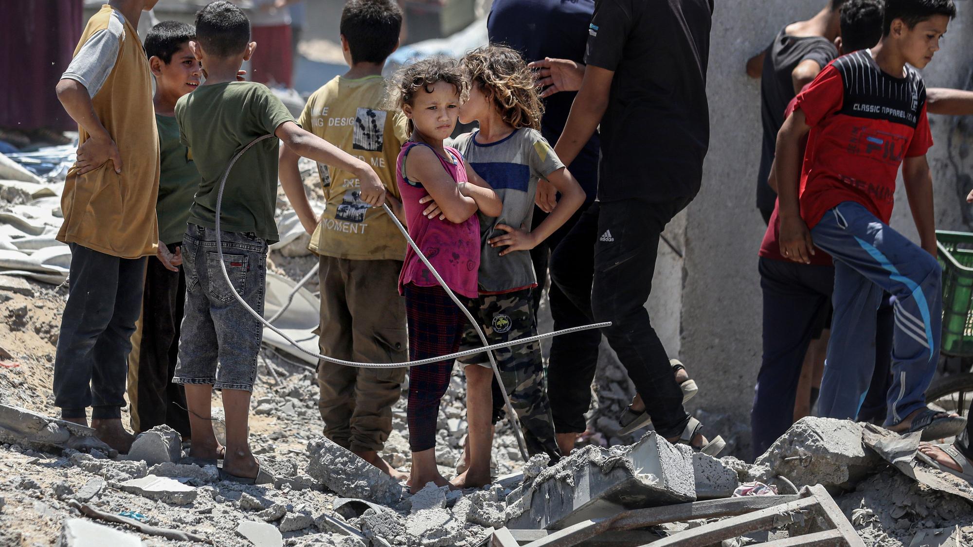 Palästinensische Kinder stehen zwischen Trümmern nach einem israelischen Angriff.