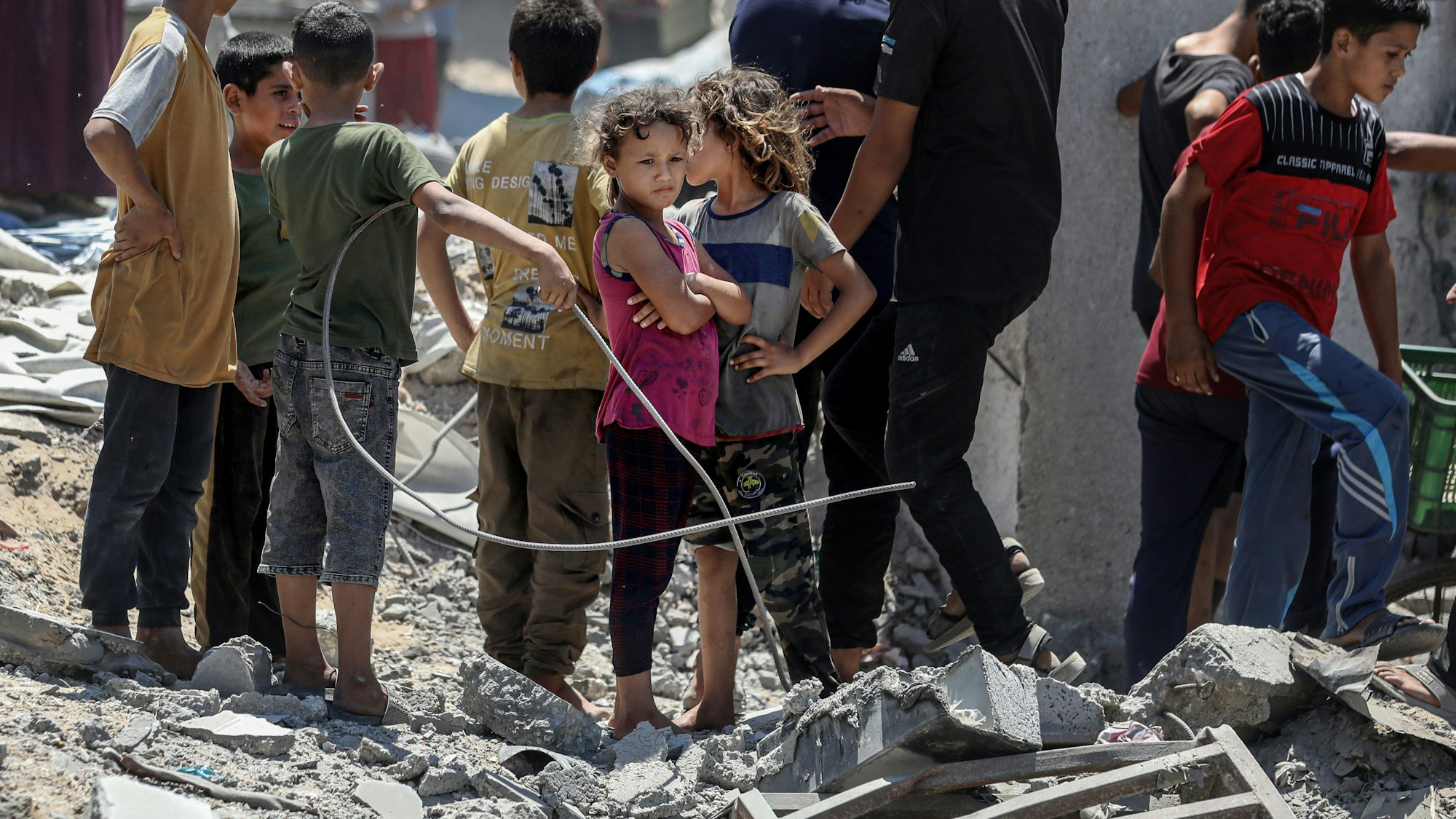 Palästinensische Kinder stehen zwischen Trümmern nach einem israelischen Angriff.