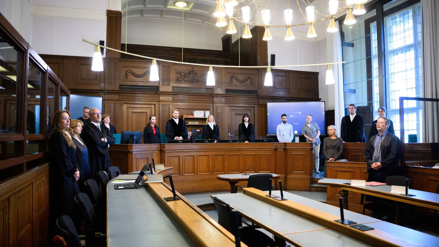 Die Vorsitzende Richterin Sylvia Busch (M) und Staatsanwalt Philipp Meyhöfer (2.v.r.) stehen beim Mordprozess gegen einen Palliativarzt, der in Berlin 15 Menschen getötet haben soll, im Landgericht Berlin.