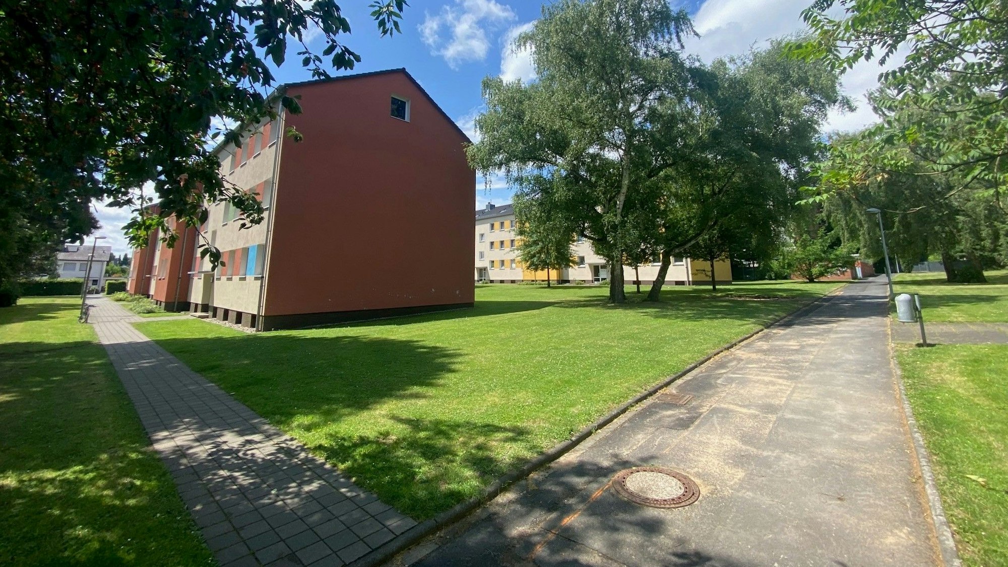 Zu sehen sind Gebäude umgeben von Grünflächen.