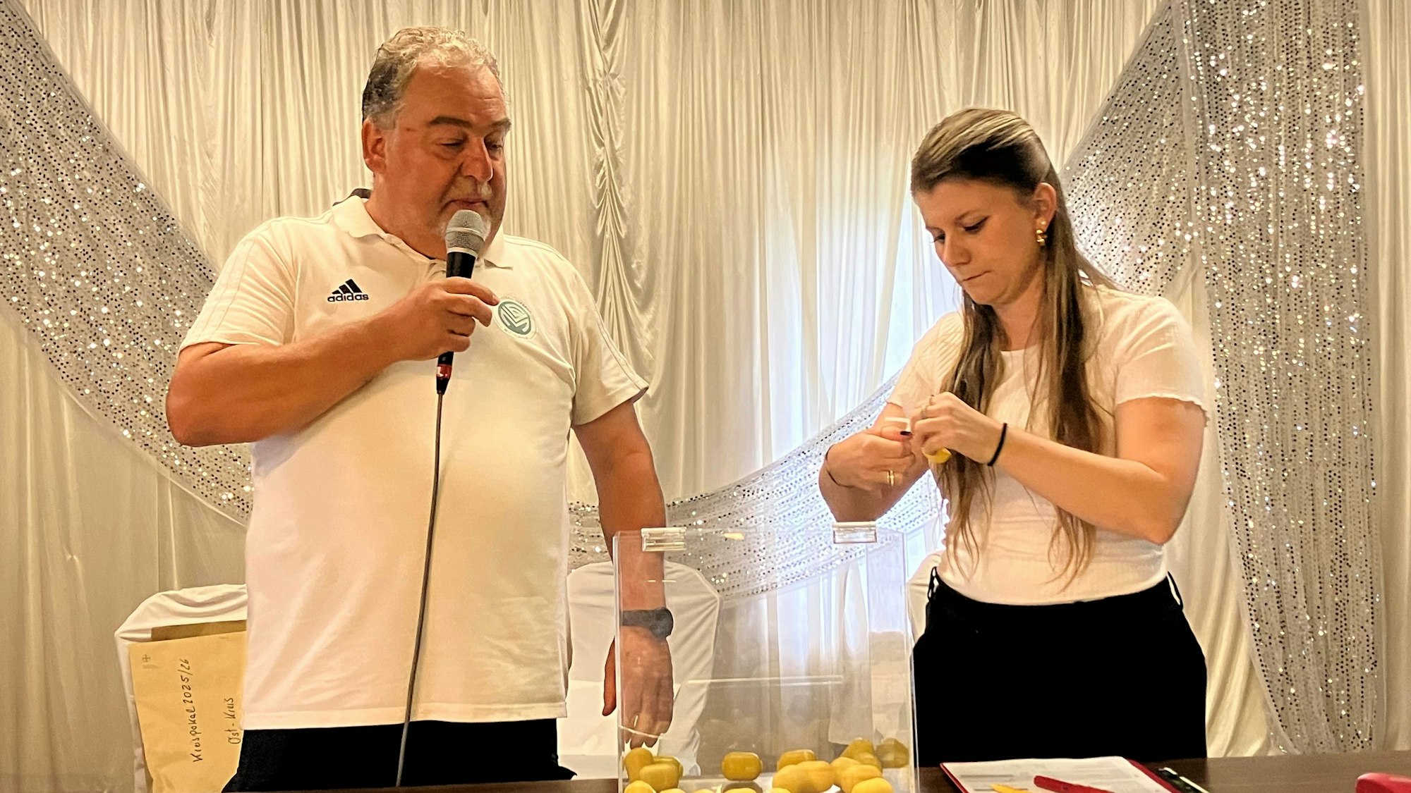 Ein Mann und eine Frau stehen an einer Lostrommel.