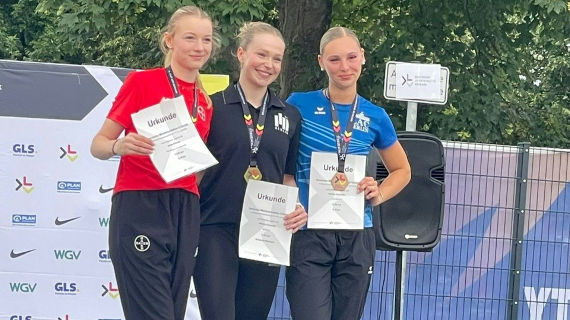 Blick auf ein Siegerpodest mit drei jungen Frauen