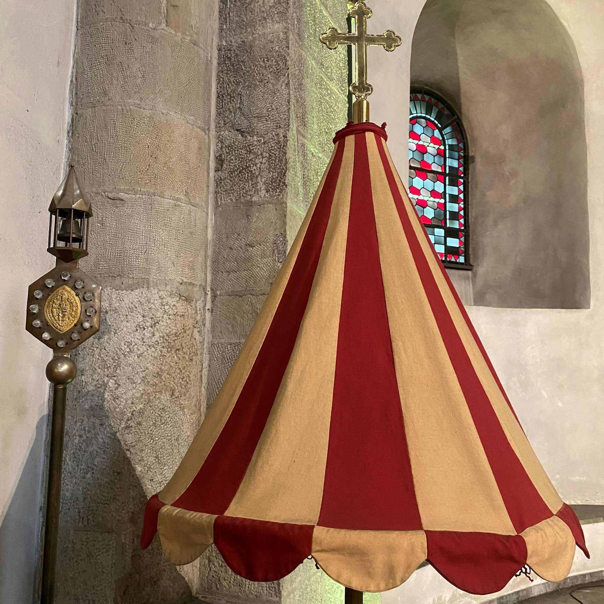 Für die Prozession: die Stange mit dem Glöckchen (Tintinnabulum) und der kegelförmige Seidenschirm.