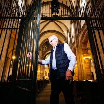 Hans-Otto Brinkkötter öffnet das schmiedeeiserne Tor in St. Aposteln.