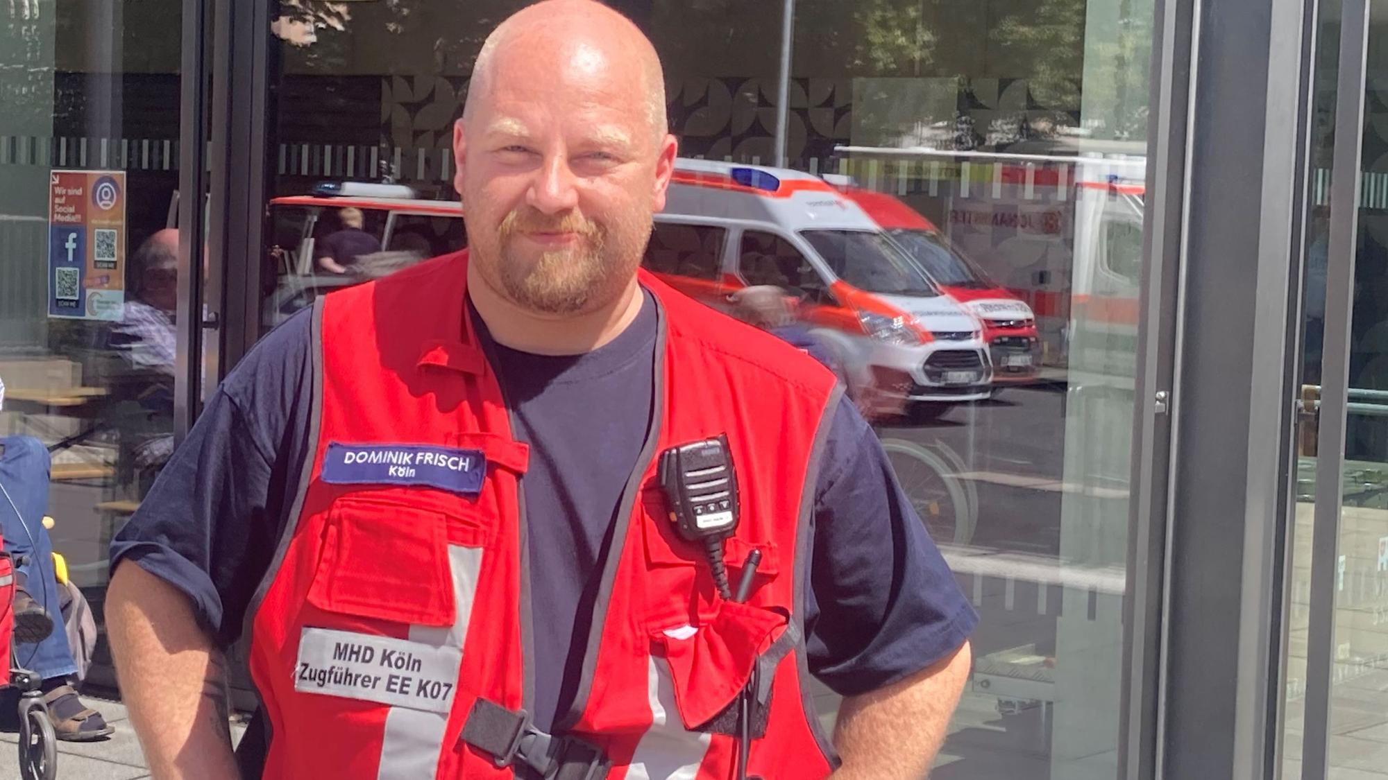 Ein Mann mit Arbeitsweste und Funkgerät.