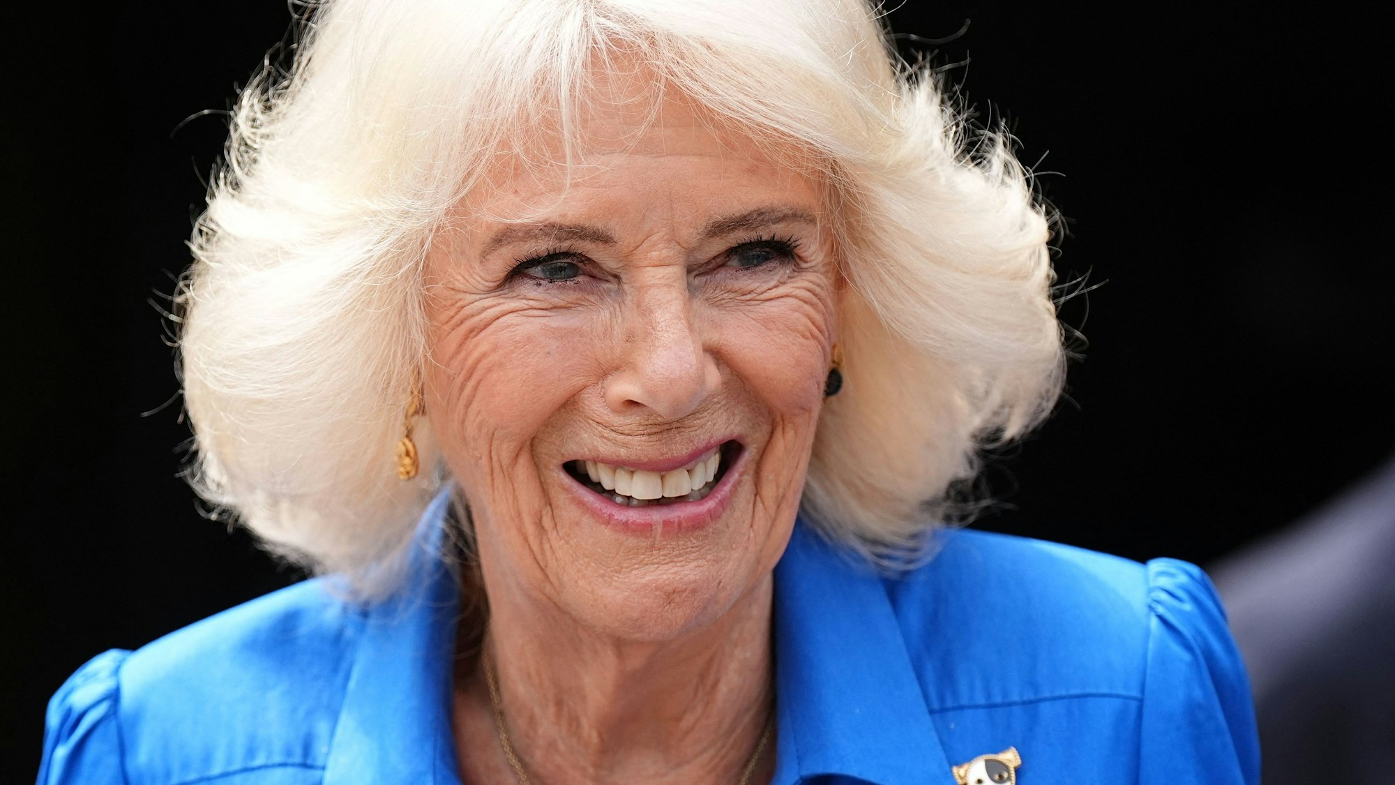 Königin Camilla lächelt in die Kamera.