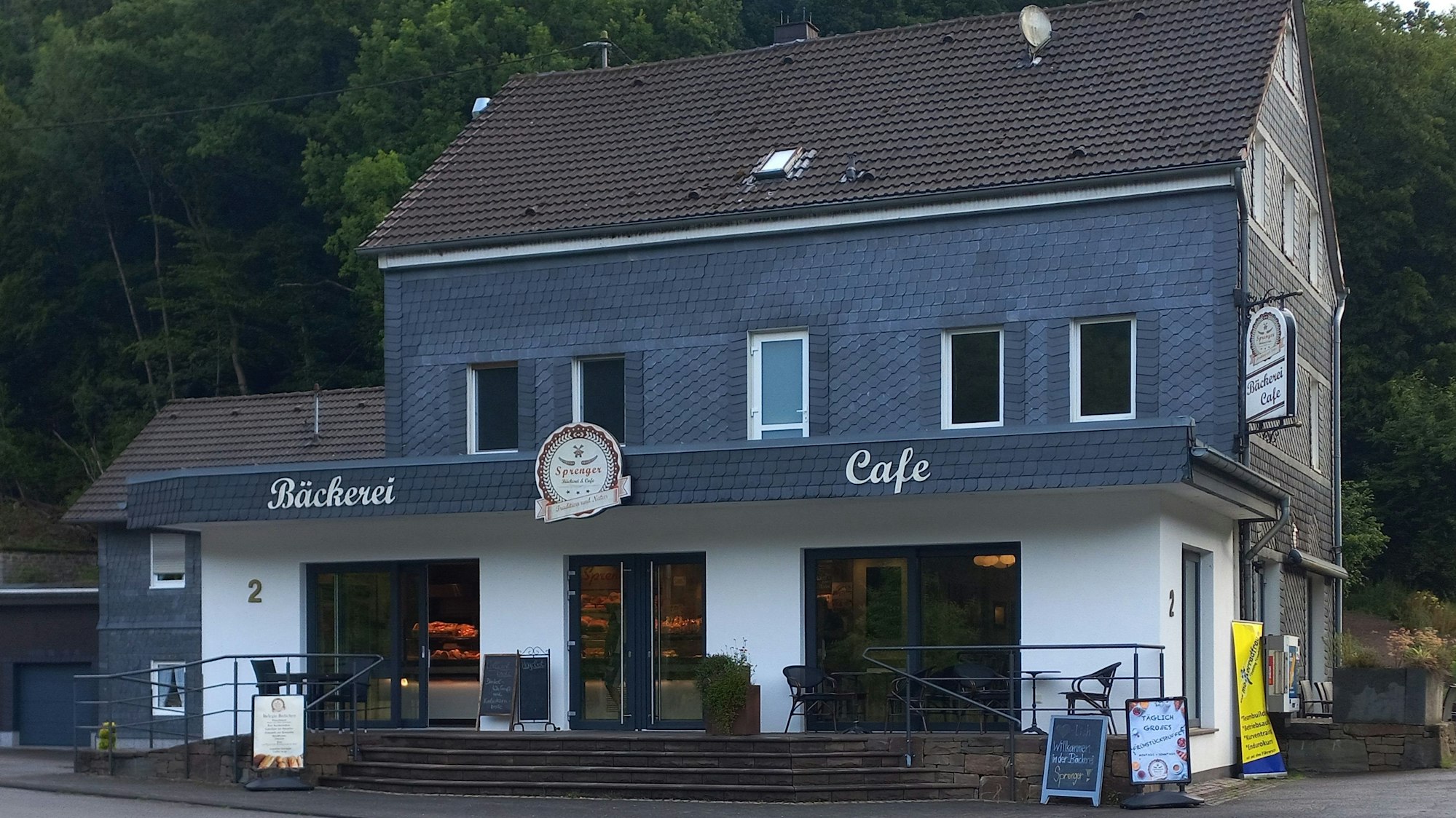 Blick auf ein Gebäude, in dessen Erdgeschoss sich ein Café befindet.