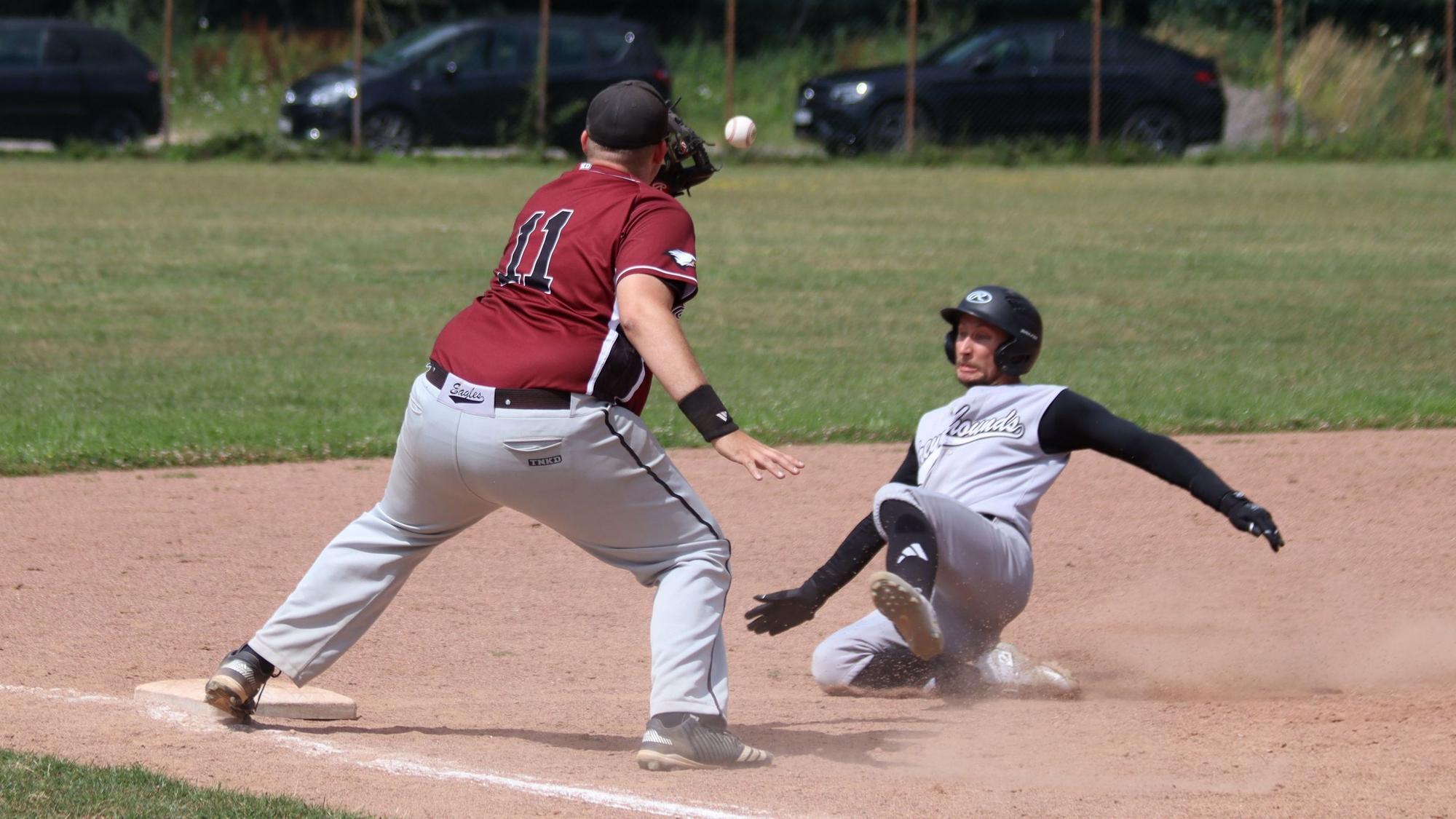 Ein Zülpicher Catcher versucht einen Ball zu fangen, während ein Gegenspieler aus Aachen sich Richtung Base wirft.