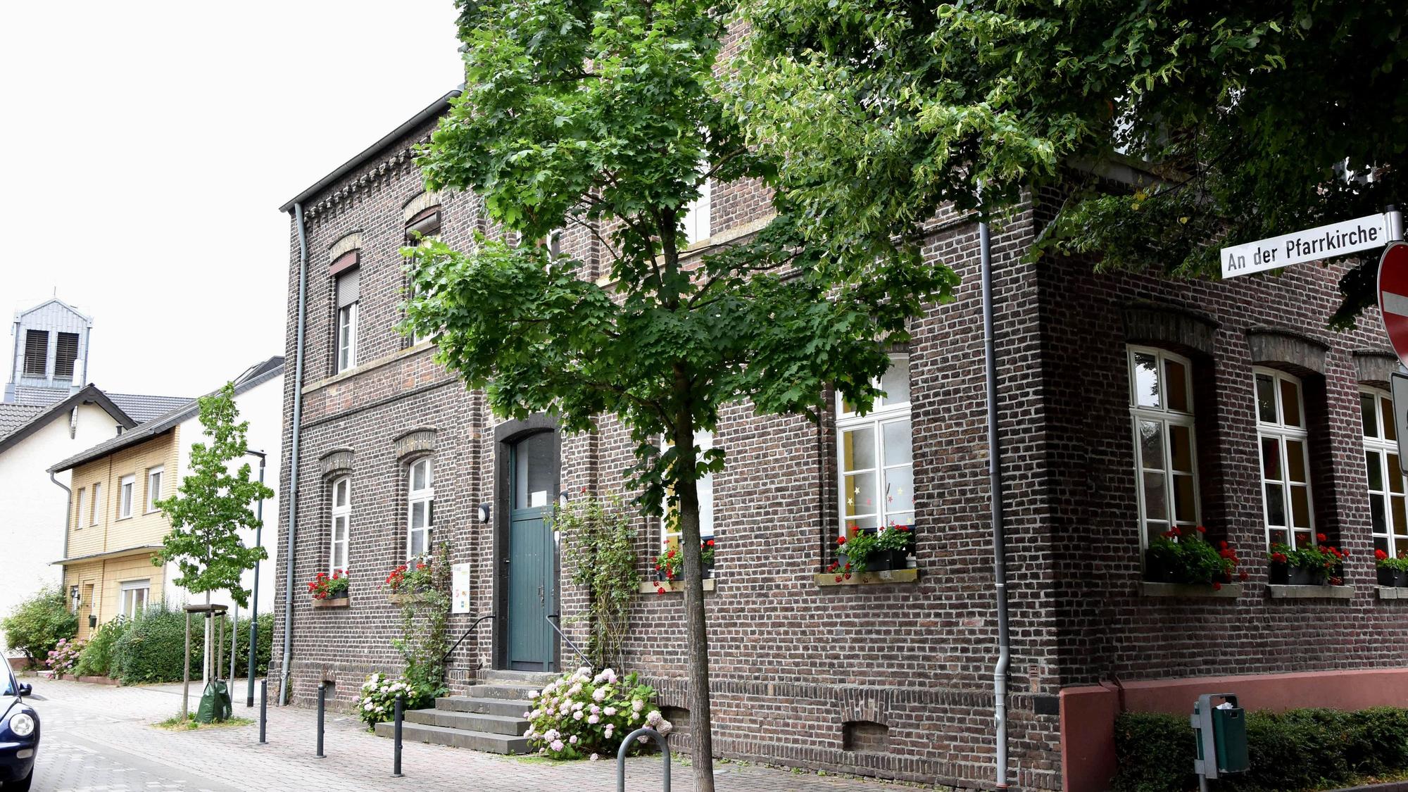 Zu sehen ist ein Backsteinhaus an einer Straße.