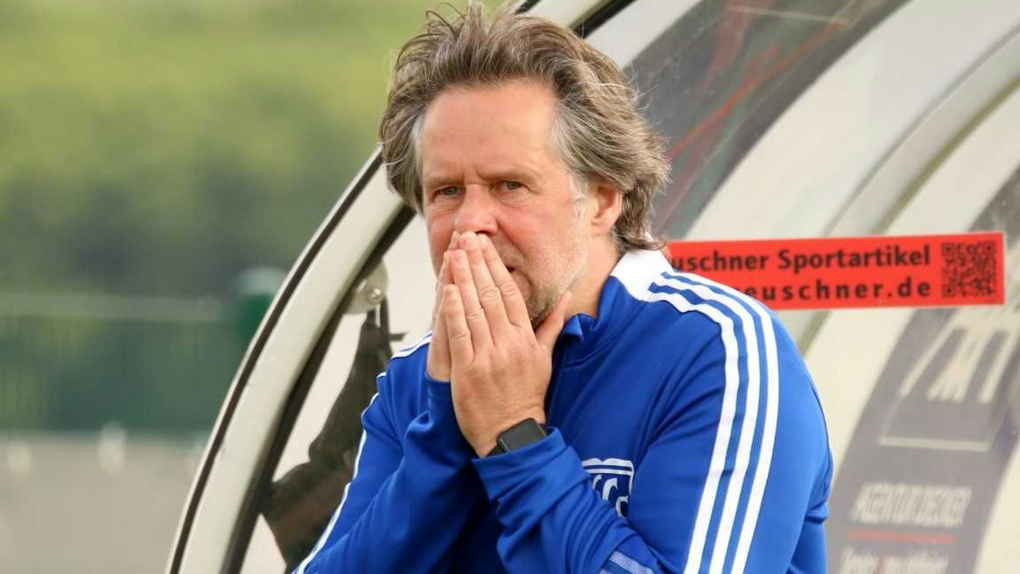 Horst Bartz verfolgt mit vor dem Gesicht gefalteten Händen ein Spiel der Wißkirchener Männer.