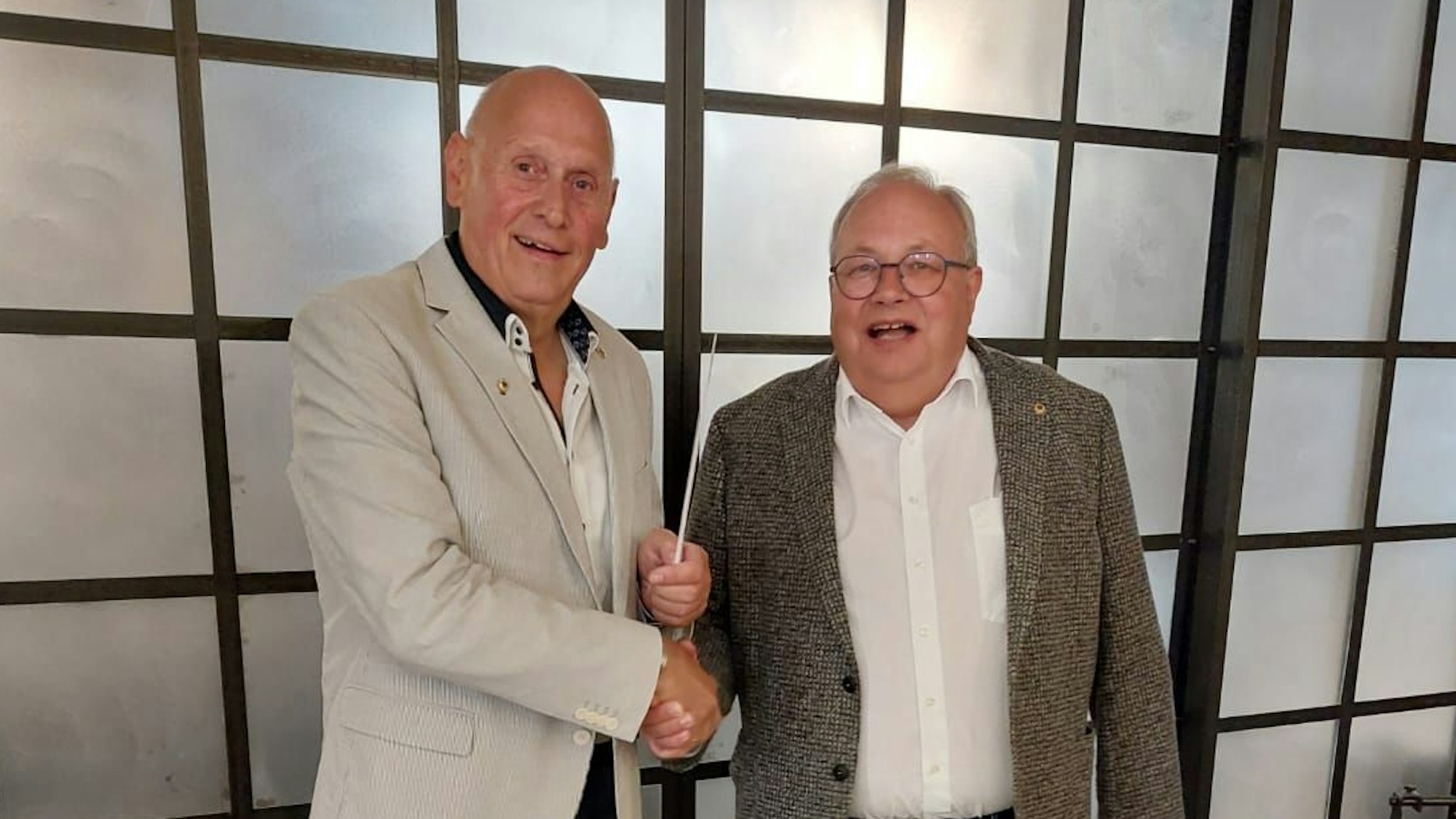 Zwei Männer reichen sich die Hand.