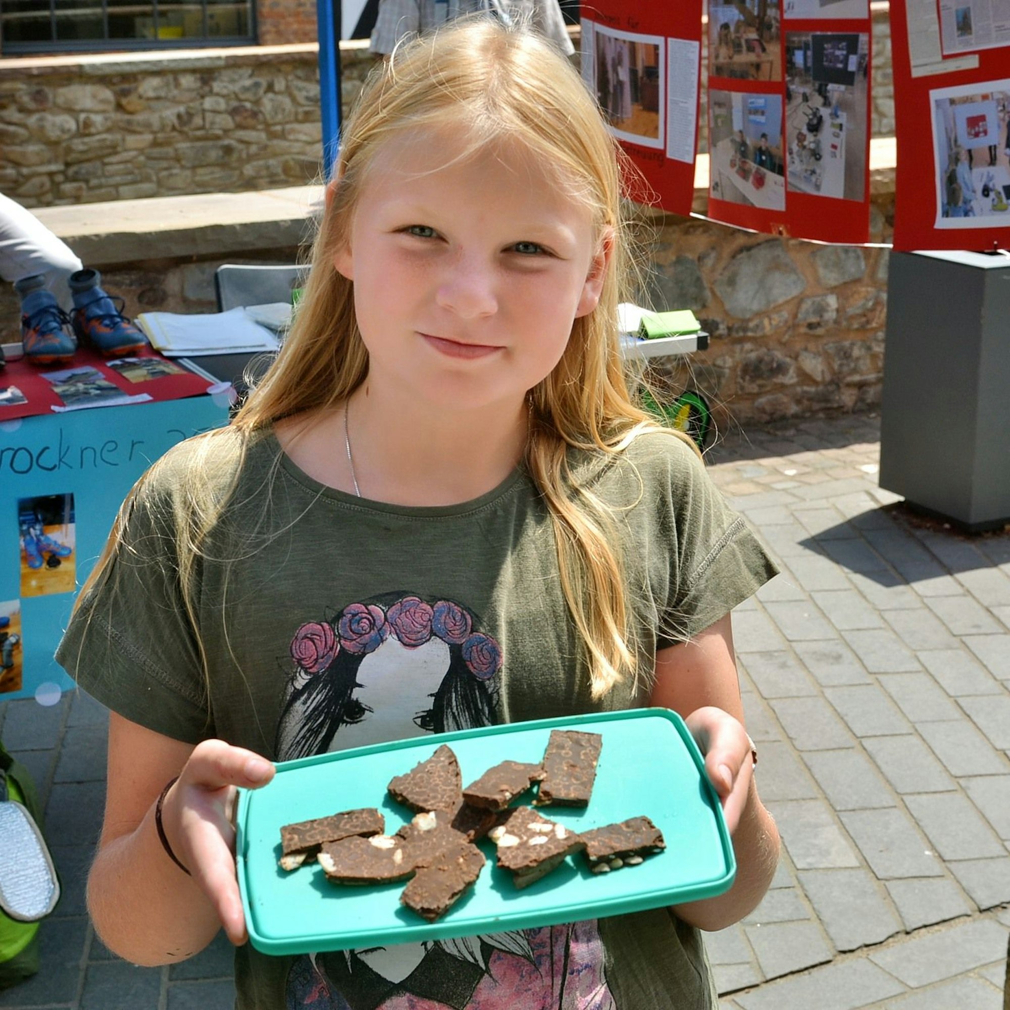 Das Mädchen Greta Schmitz hält eine Unterlage, auf der Schokoladenstücke liegen.
