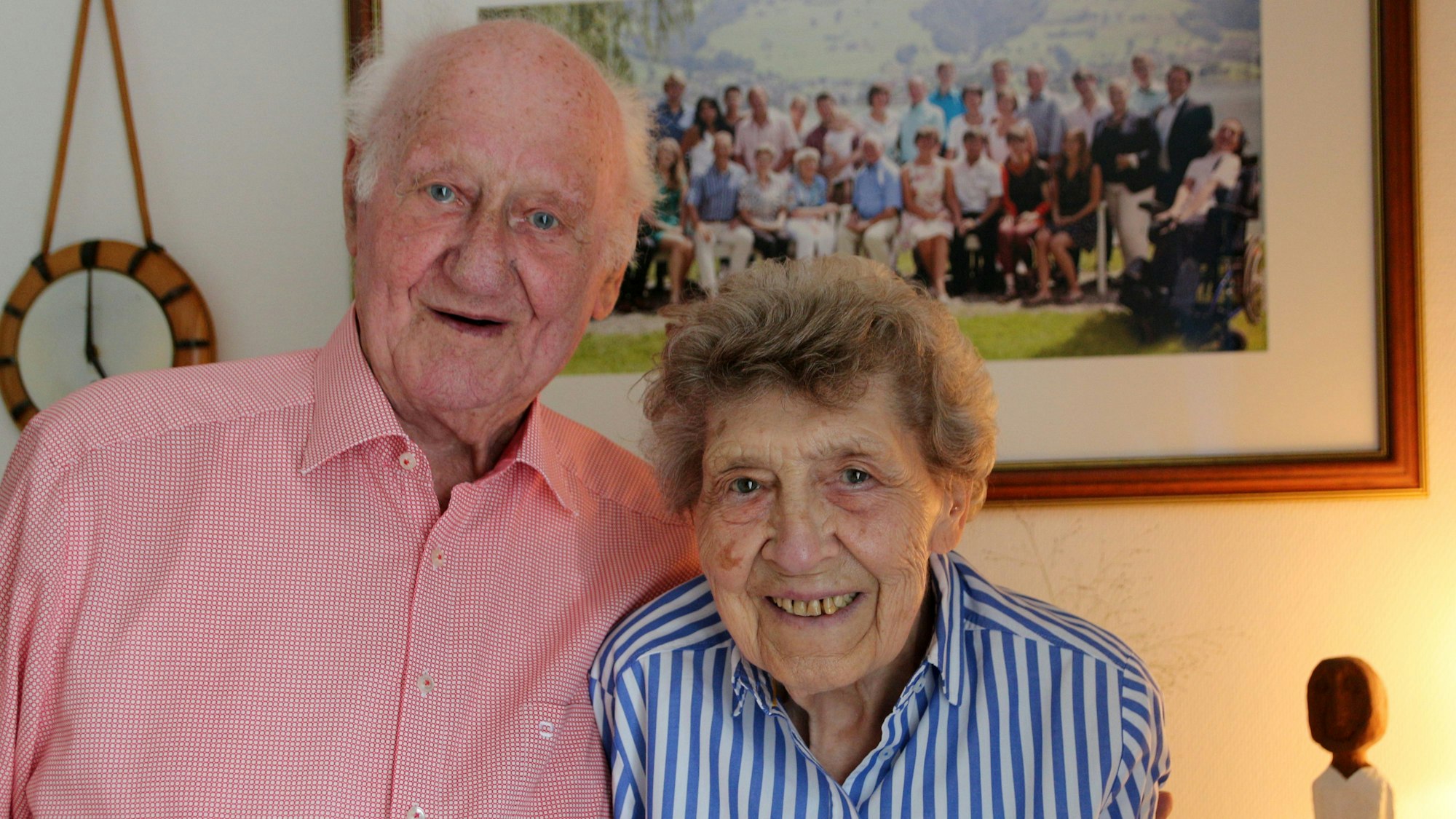 Ein älteres Ehepaar - die Frau und der Mann lächeln in die Kamera.