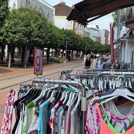 Auf dem Bild ist eine Einkaufsstraße zu sehen.