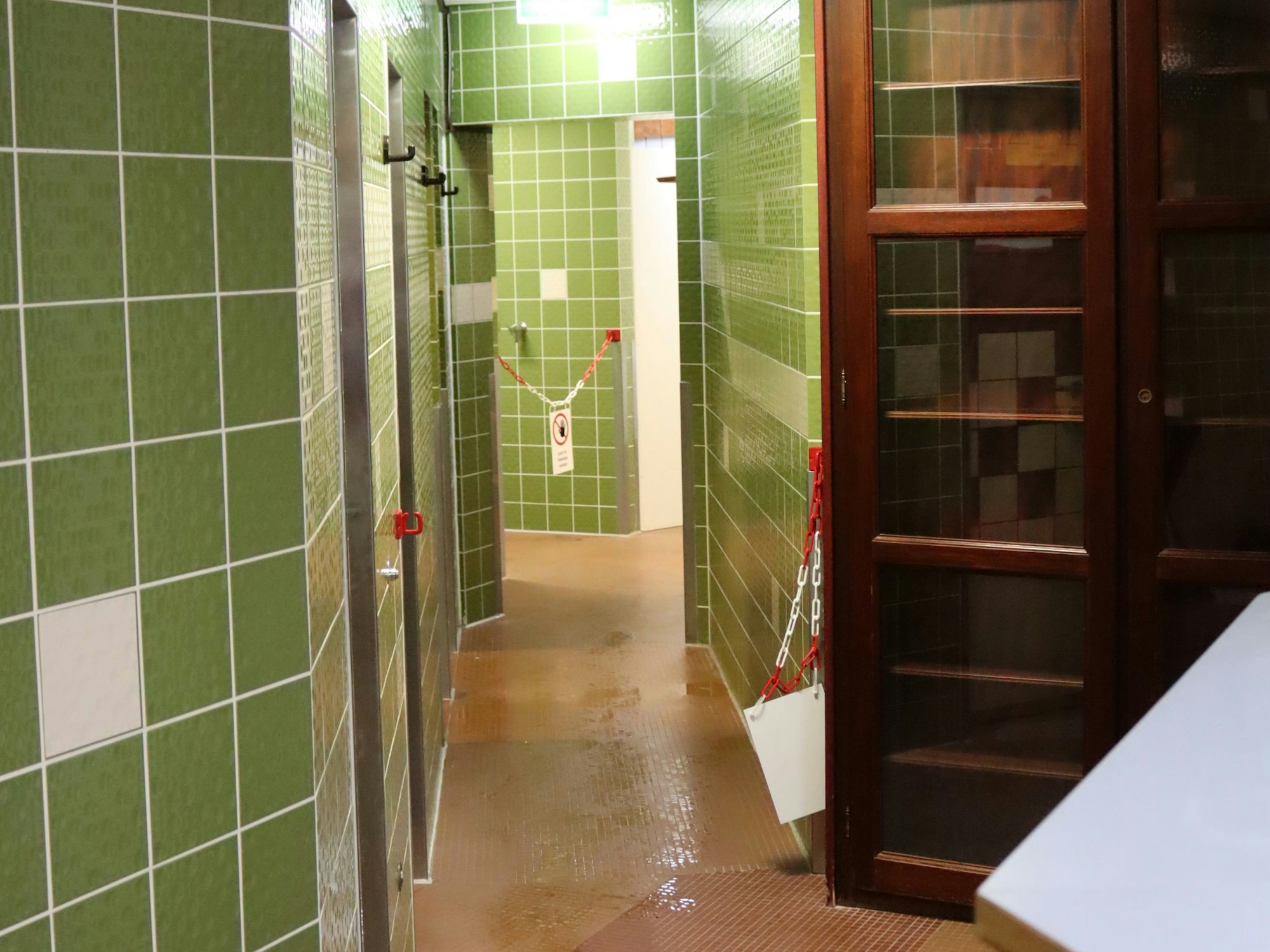 Gründe Fliesen, braune Böden und ein rustikaler Holzschrank stehen in dem Bereich, der zur Kurmittelabgabestelle umgerüstet werden soll.