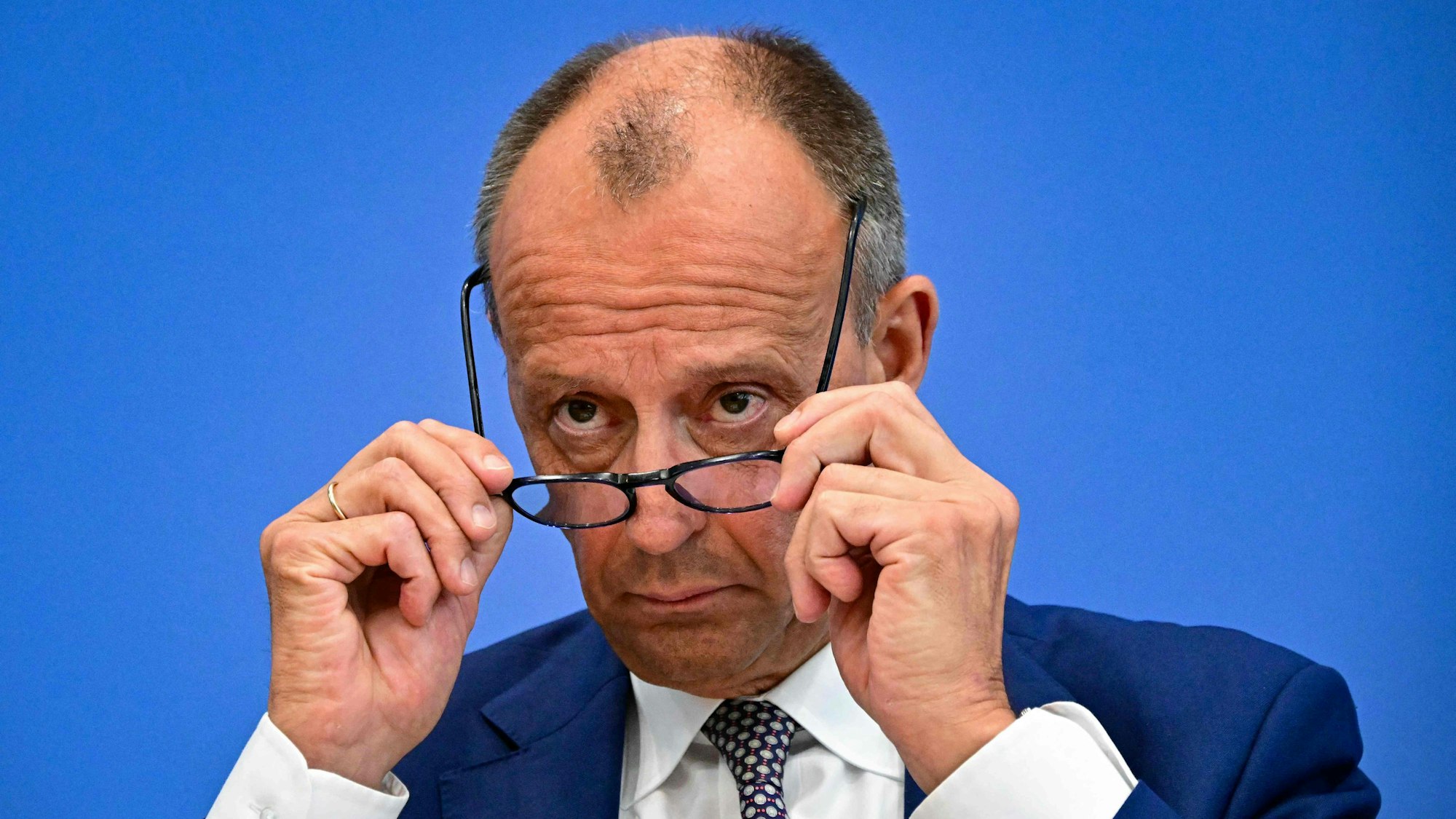 German Chancellor Friedrich Merz adjusts his glasses while addressing a press conference on home and foreign policy in Berlin on July 18, 2025. (Photo by Tobias SCHWARZ / AFP)