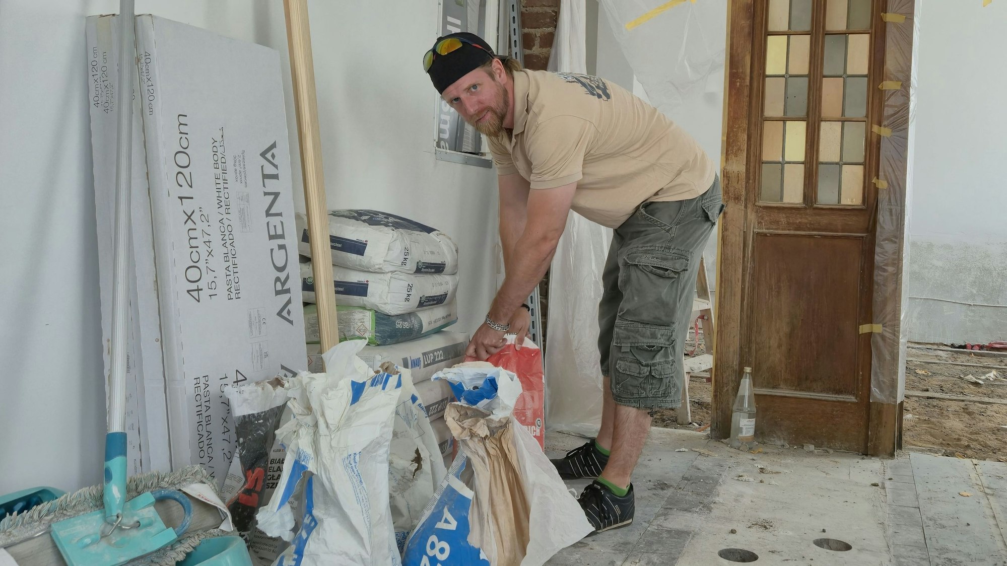 Pächter Daniel Schmidt trägt Säcke auf der Baustelle.