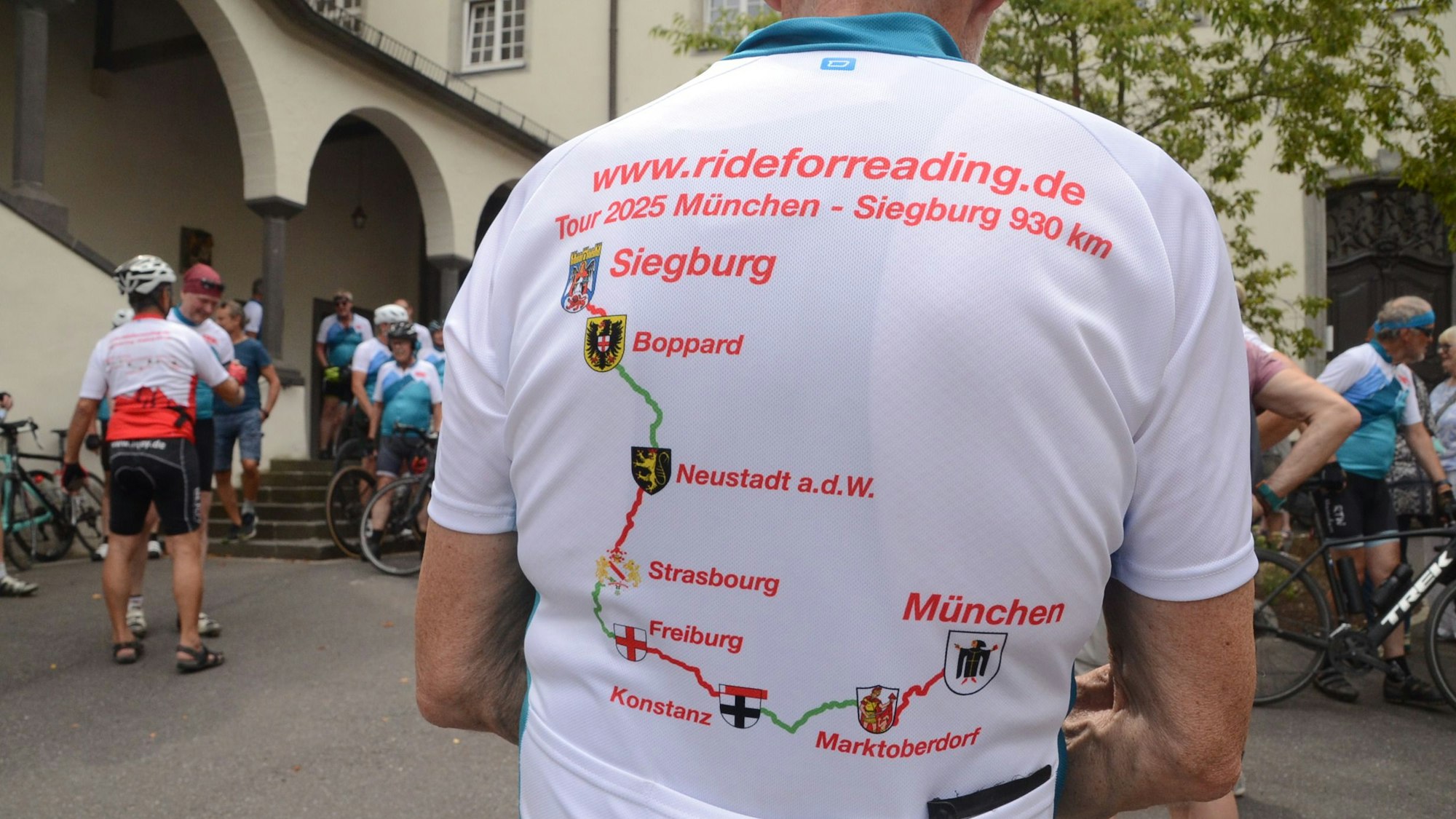 Auf den Rücken eines Fahrradtrikots ist die Strecke einer Tour von Münschen nach Siegburg gedruckt.