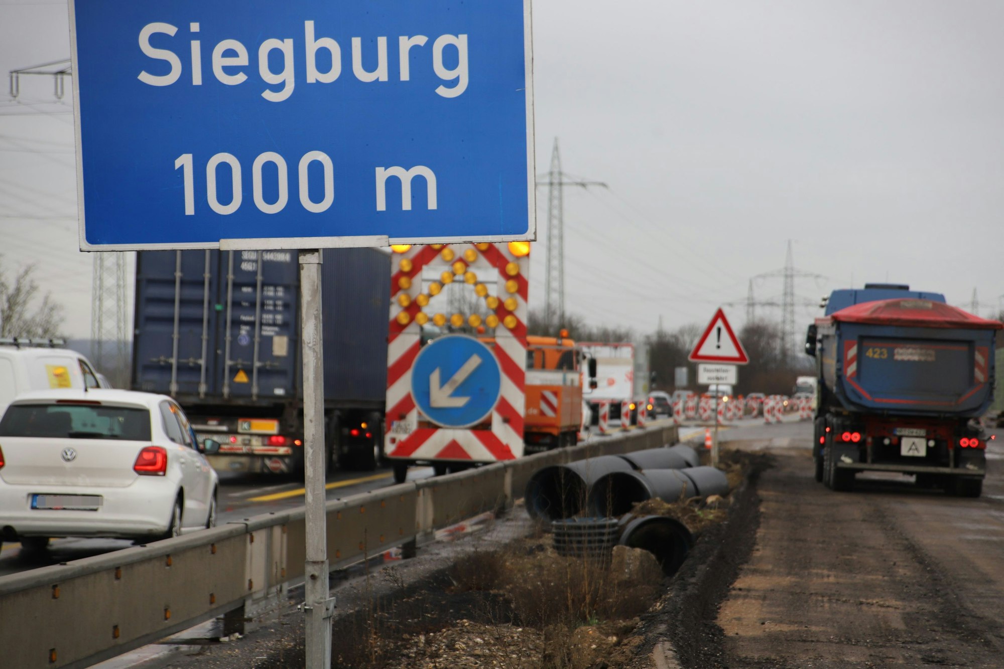 Autos und Lastwagen an einer Autobahnbaustelle; der Verkehr stockt.