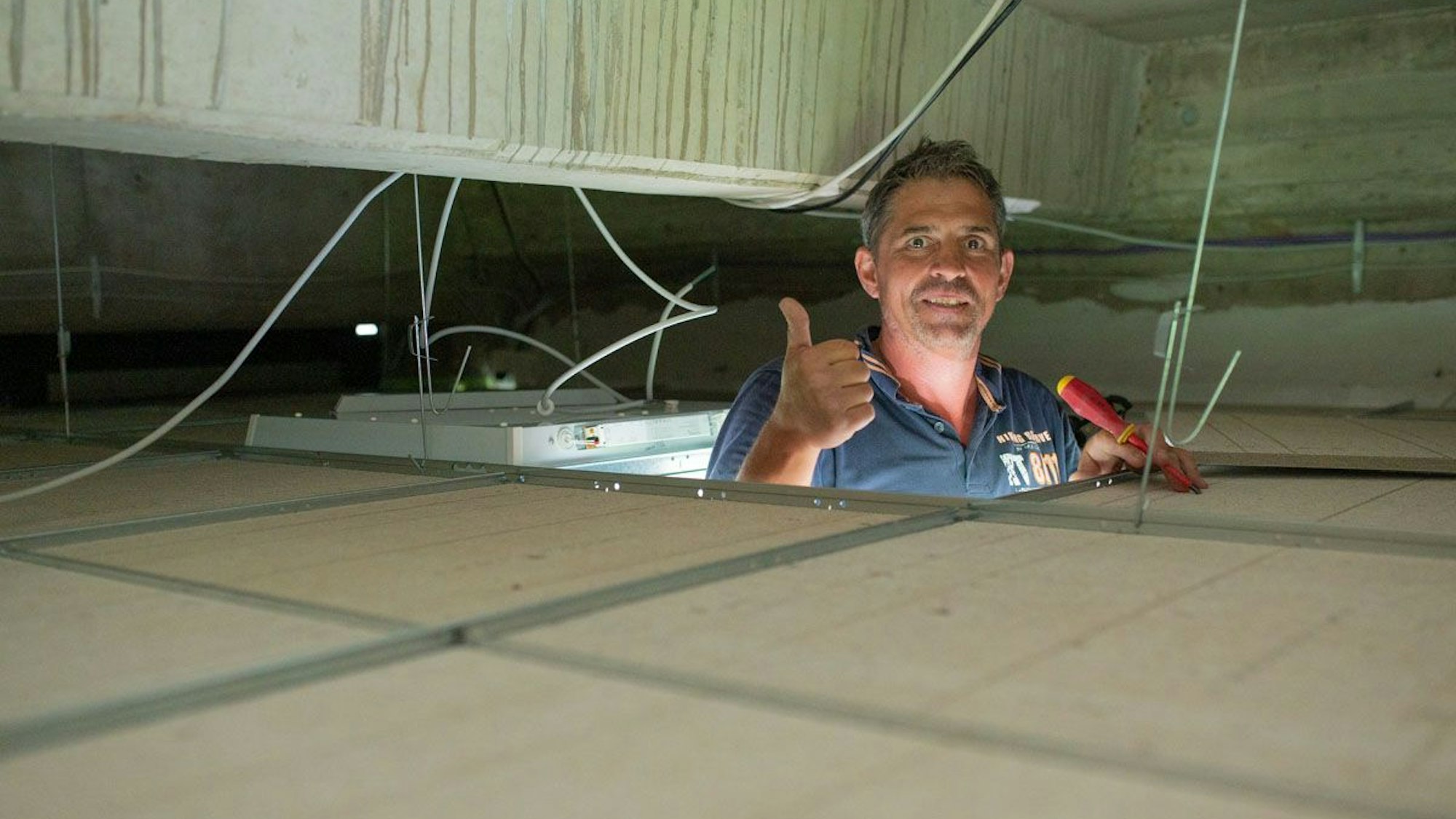 Auf dem Bild ist ein Handwerker bei Deckenarbeiten zu sehen.