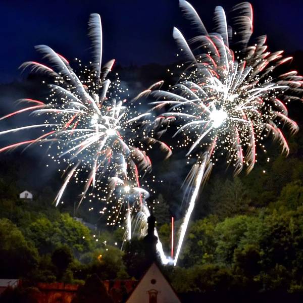 Vor einem dunklen Himmel explodieren Feuerwerkskörper.