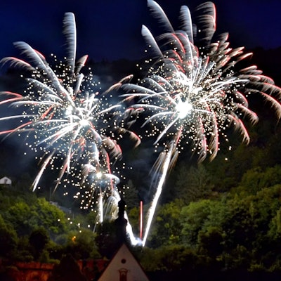 Vor einem dunklen Himmel explodieren Feuerwerkskörper.