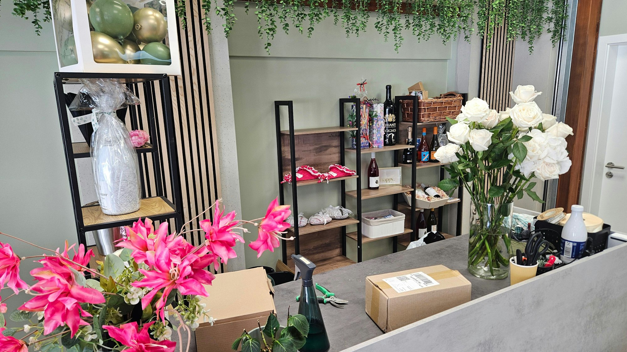 Verschiedene Blumen stehen auf einer Verkaufstheke.