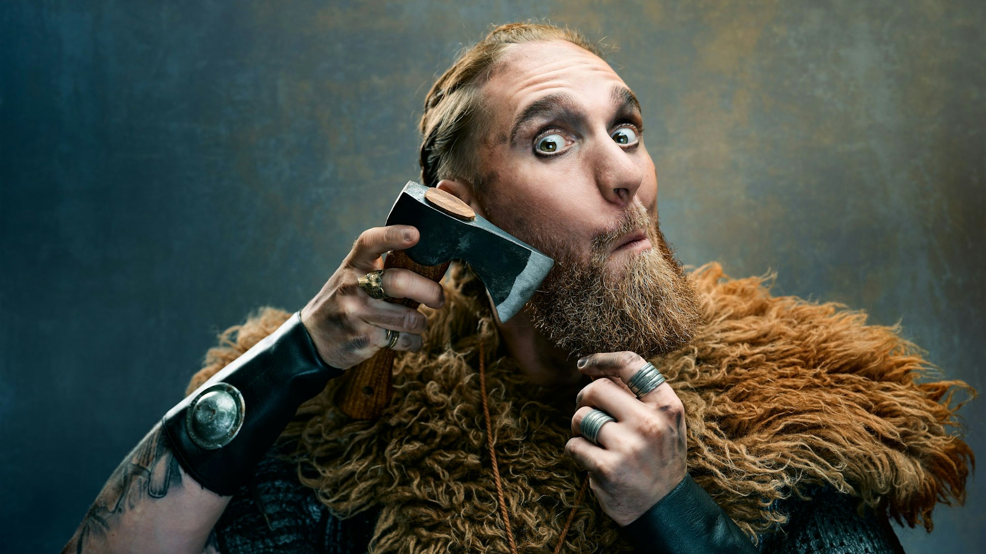 Lennard Rosar ist als Wikinger verkleidet und tut so, als würde er sich seinen Bart mit einer Handaxt stutzen.