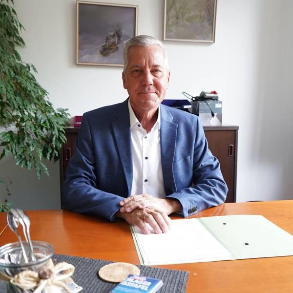Das Foto zeigt einen Mann am Schreibtisch.
