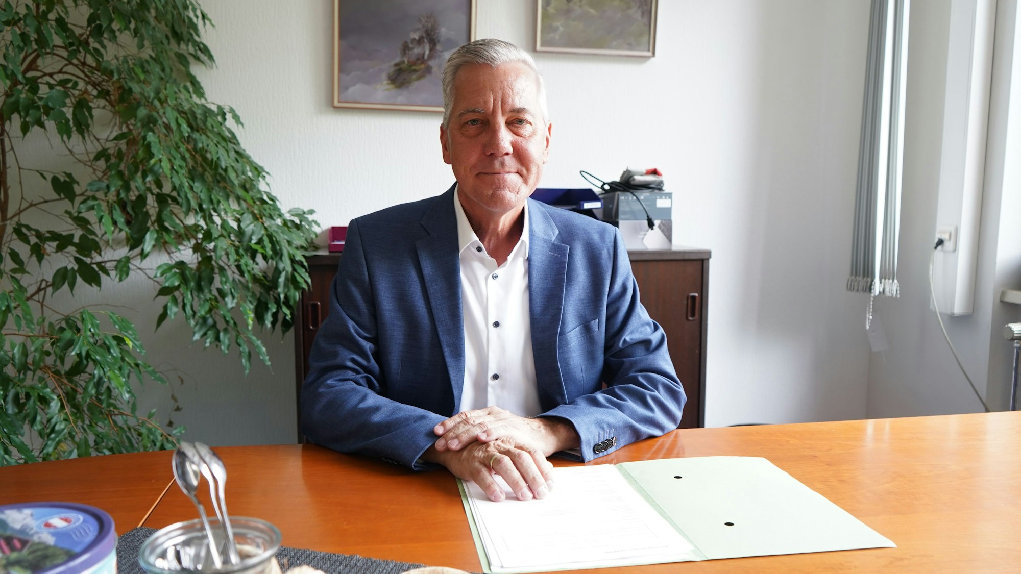 Das Foto zeigt einen Mann am Schreibtisch.