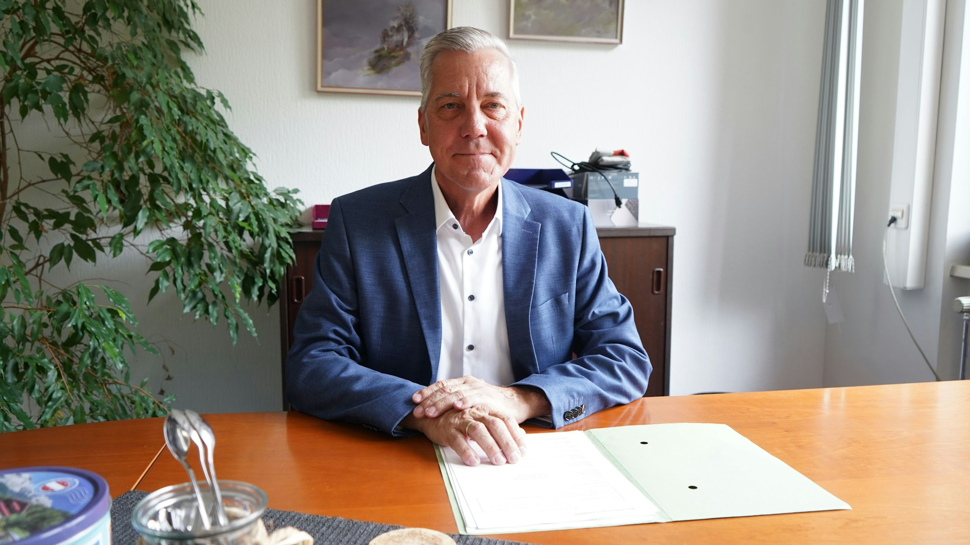 Das Foto zeigt einen Mann am Schreibtisch.