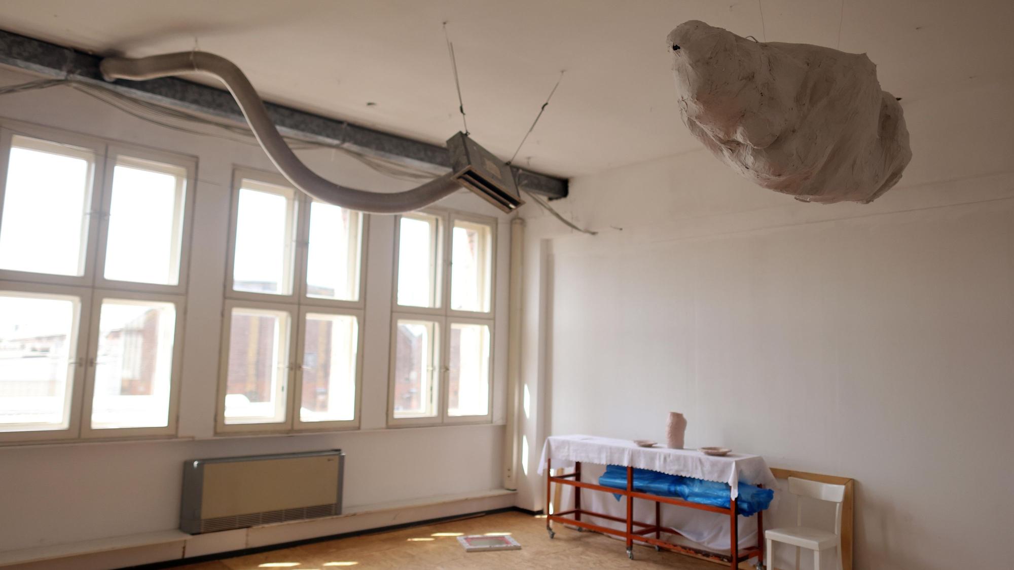 Ein Raum, in dem ein Lüftungsschlauch wie eine Schlange aus der Wand kommt.