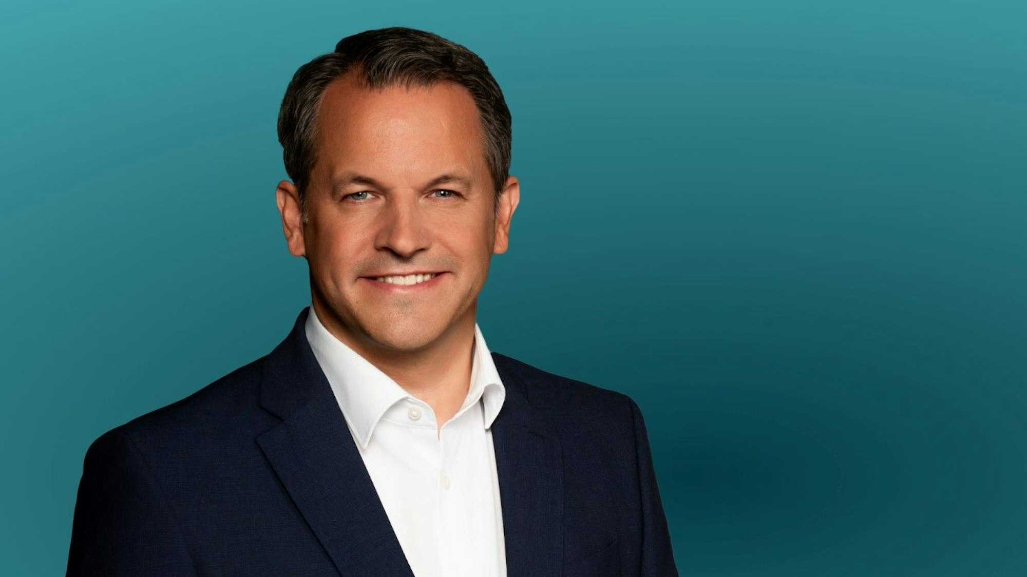 Ein Mann lächelt in die Kamera.