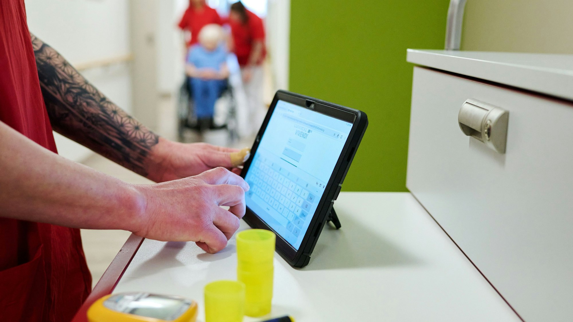 Eine Pflegekraft dokumentiert ihre Arbeit auf einem Tablet-Computer.