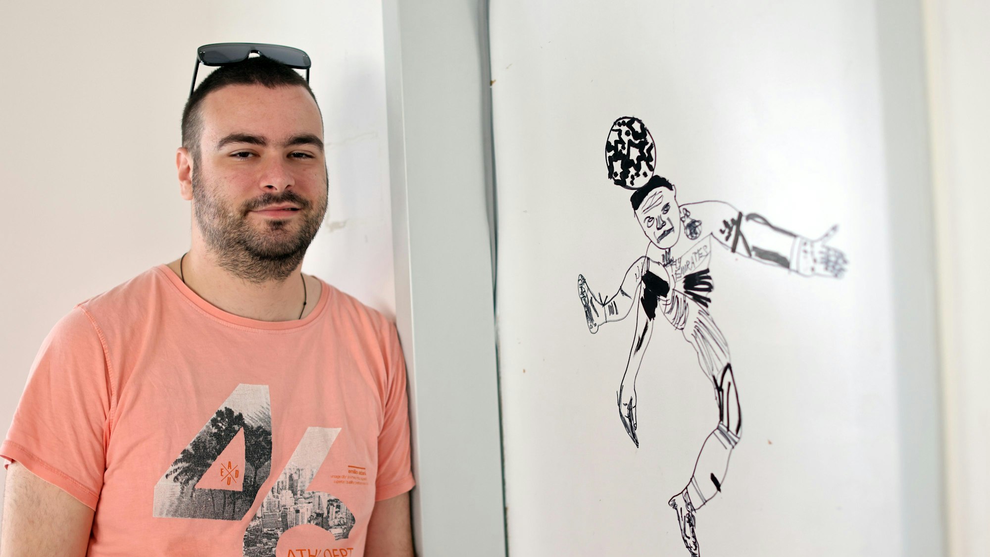 Ein junger Mann und eine Zeichnung eines Fußballspielers.