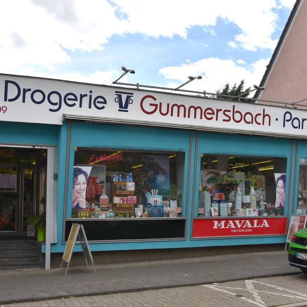 Zu sehen ist ein Drogeriegeschäft an einer Straße.