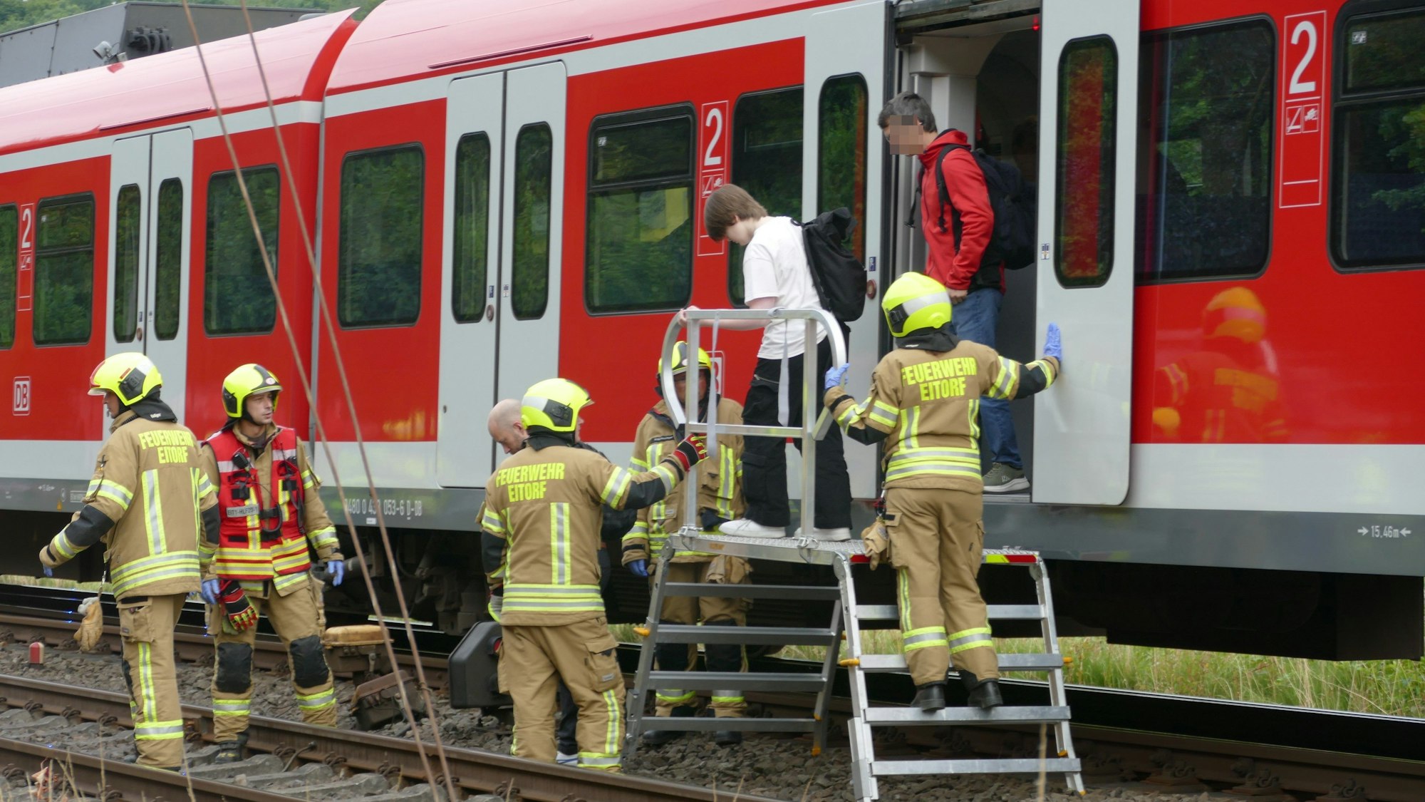 Die 130 Menschen in der S-Bahn mussten den Zug verlassen. Feuerwehrleute halfen ihnen über die Gleise.