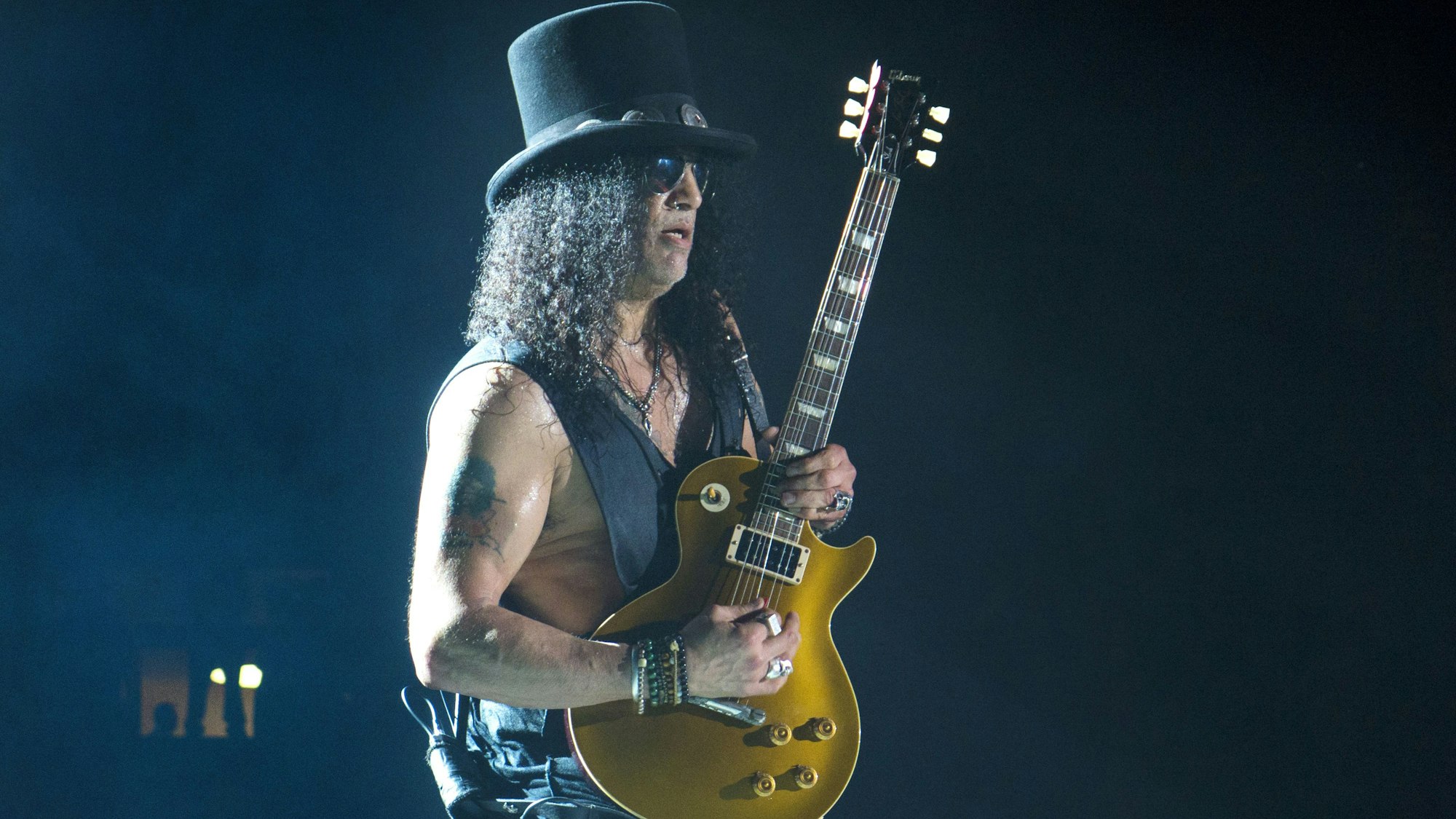 Slash mit Gitarre und Hut auf der Bühne.