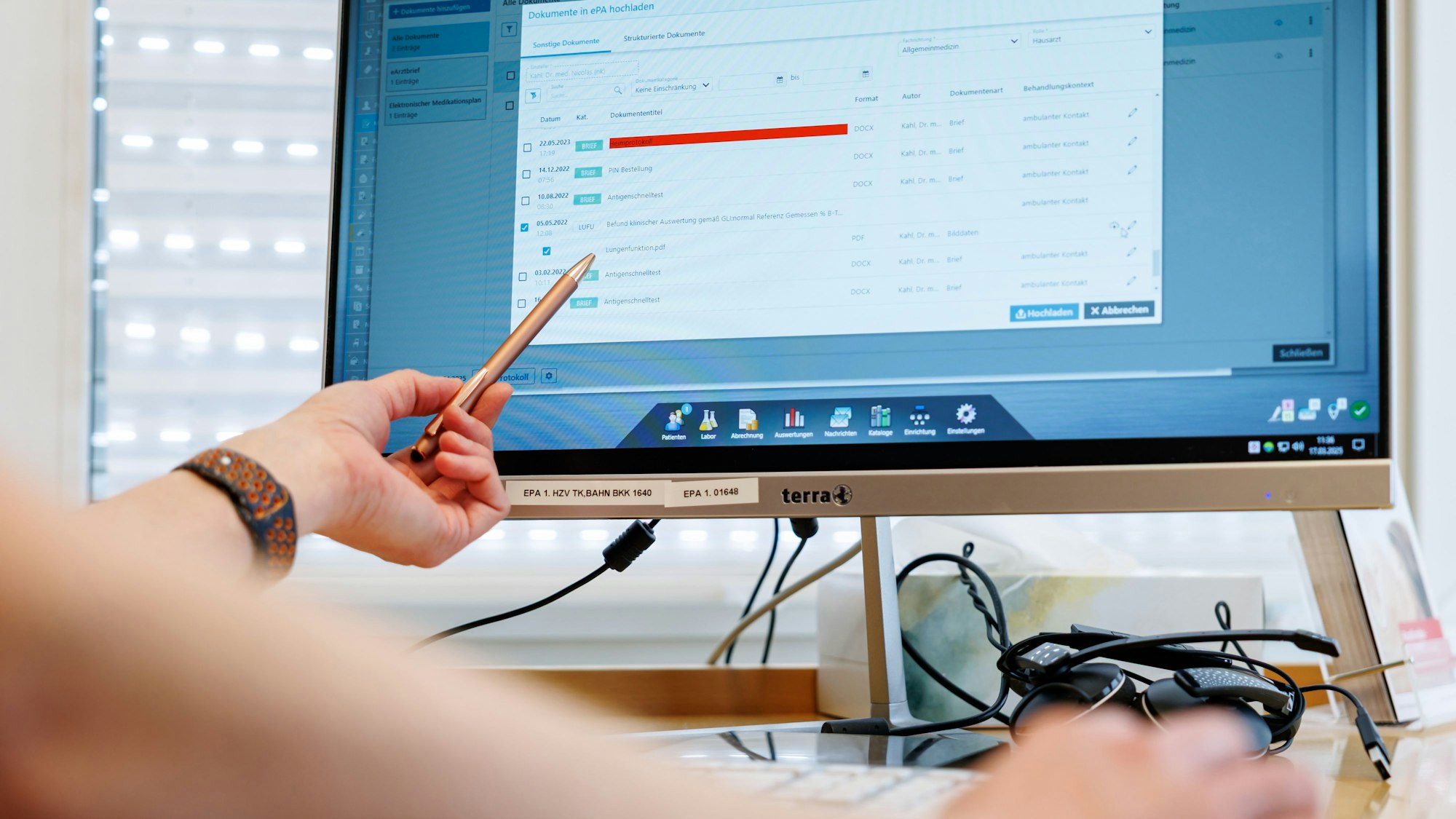 Ein Hausarzt lädt in seiner Praxis Dokumente in eine elektronische Patientenakte „ePA“.