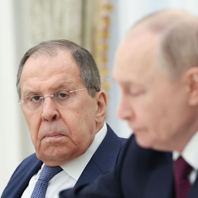 Russlands Außenminister Sergej Lawrow schaut in die Kamera. Im Vordergrund ist Kremlchef Wladimir Putin unscharf zu sehen. (Archivbild)
