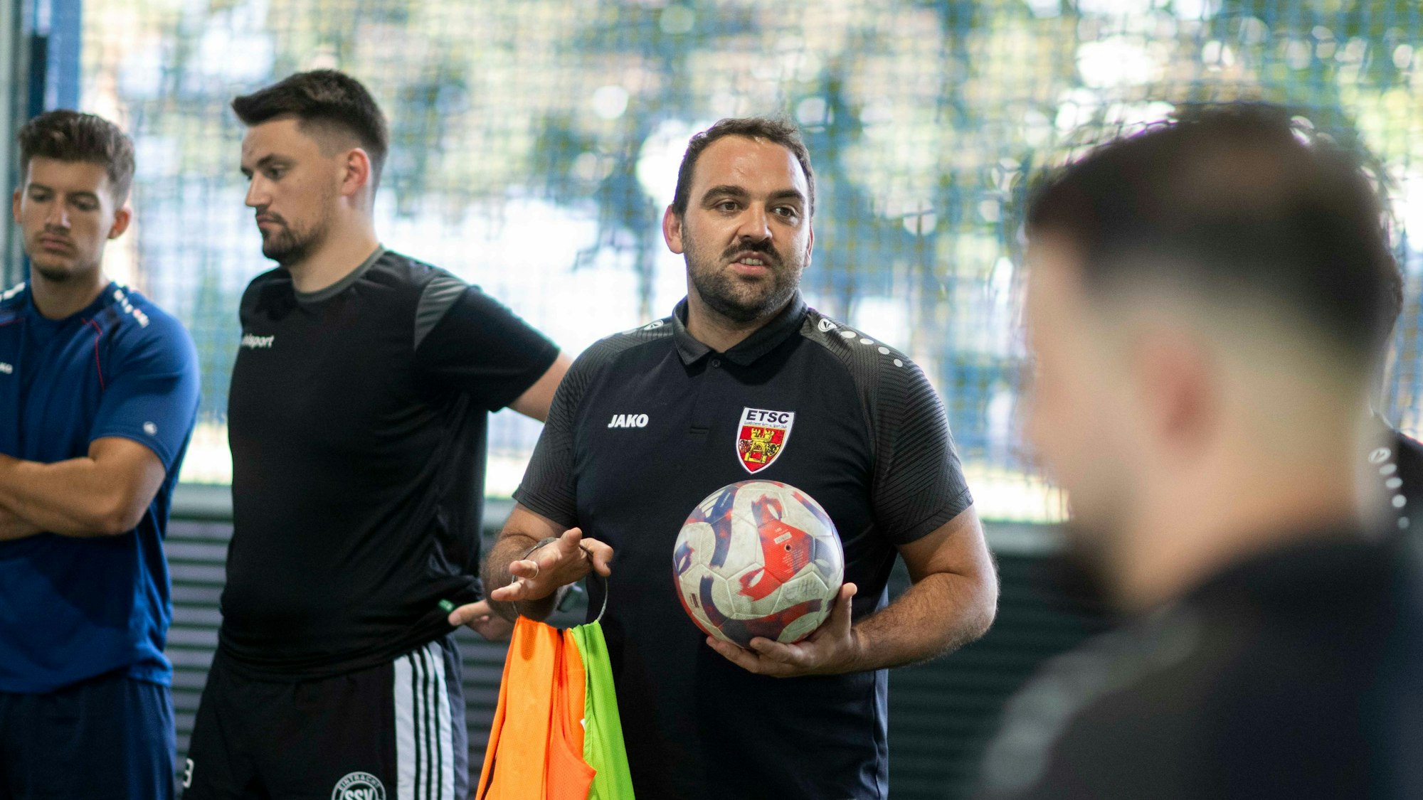 Salih Yavuz hält einen Ball in einer Hand und redet mit seinen Spielern.