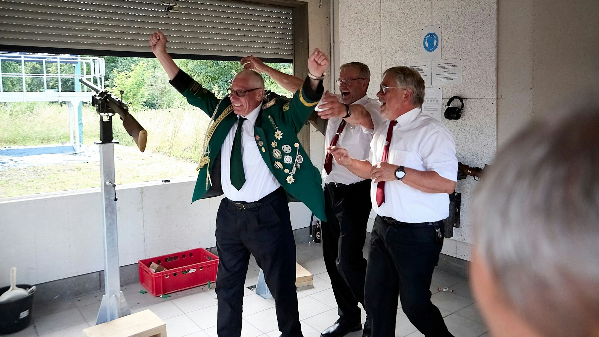 Reiner Müller jubelt mit zwei weiteren Männern.