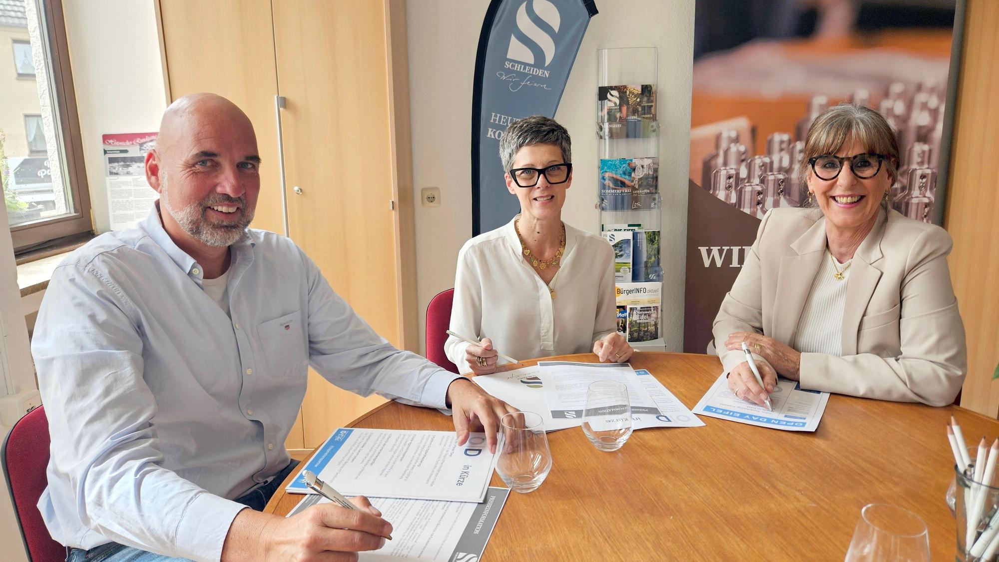 Hubert Schmidt, Bianka Renn und Petra Schumacher-Hendus sitzen an einem Tisch und haben Unterlagen vor sich liegen.