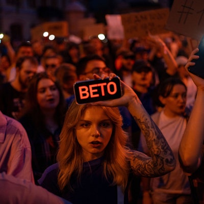 22.07.2025, Ukraine, Kiew: Eine Frau hält während des Protests gegen ein Gesetz, das die Unabhängigkeit von Organen zur Korruptionsbekämpfung beschränkt, ein Telefon mit der Aufschrift „Veto“. Foto: Alex Babenko/AP/dpa +++ dpa-Bildfunk +++