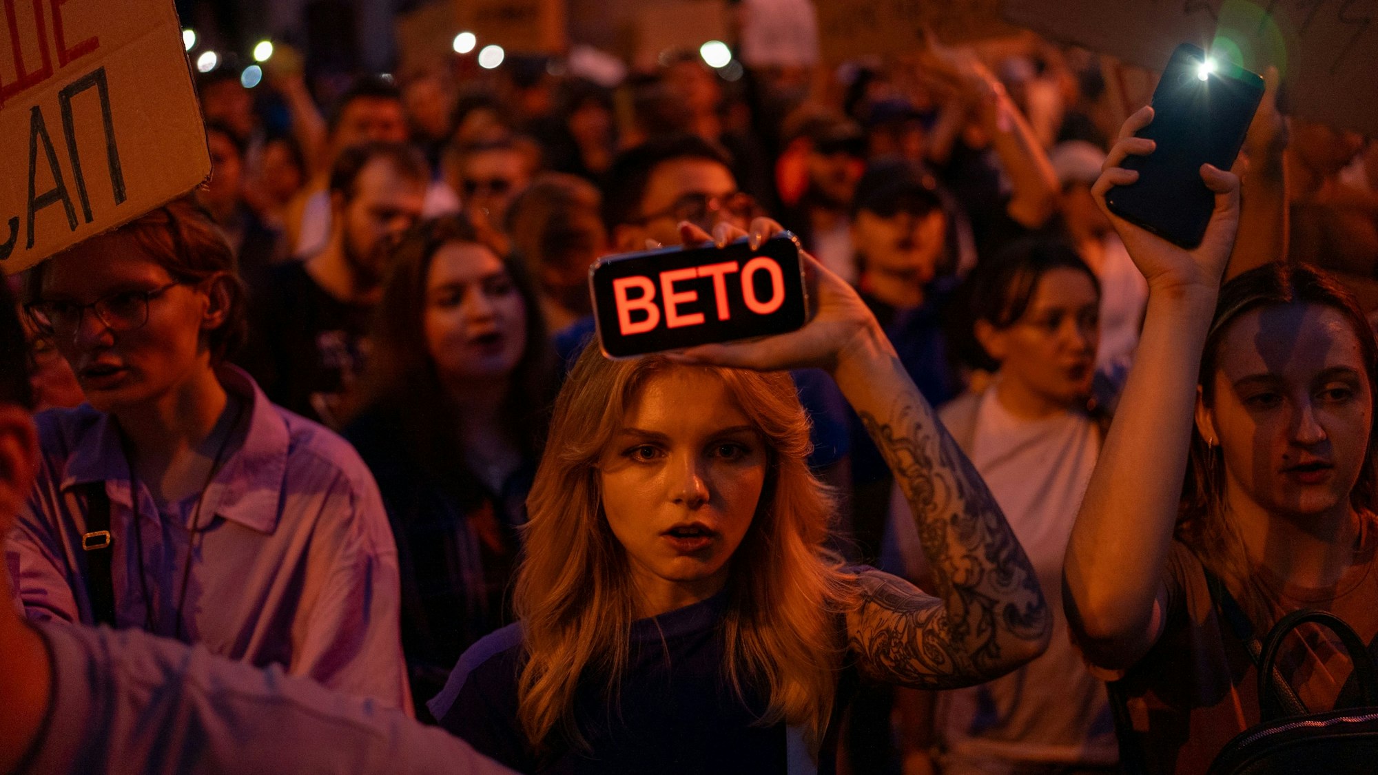 22.07.2025, Ukraine, Kiew: Eine Frau hält während des Protests gegen ein Gesetz, das die Unabhängigkeit von Organen zur Korruptionsbekämpfung beschränkt, ein Telefon mit der Aufschrift „Veto“. Foto: Alex Babenko/AP/dpa +++ dpa-Bildfunk +++