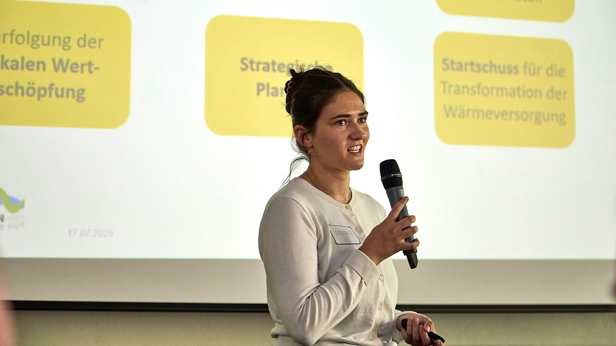 Alexandra Seliger steht vor einer Leinwand.