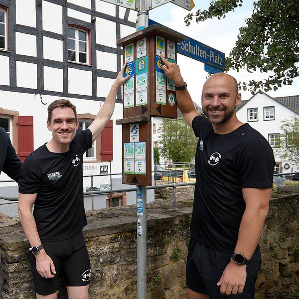 Den Eifelsteig fest im Blick haben Henrik Züll (von links), Sebastian Nelles und Andreas Winkler (rechts), die neben einem Wanderwegweiser stehen.